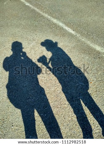 shadows of tourists on asphalt