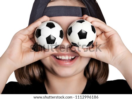 The lucky girl in the baseball cap closed her eyes with soccer balls. Isolated on white background.