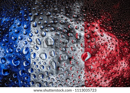 Close-up of a drop of water against a background of the national flag of  France  on an isolated background
