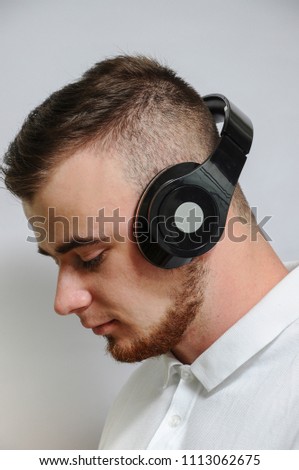 Young man. hipster, in headphones, ford, listening to music, positive emotions.