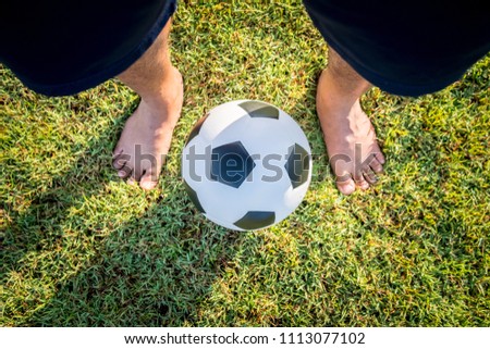 Above view of foot man playing classic leather soccer ball on grass field in the arena stadium. Traditional football equipment to play competitive game. Sport championship tournament concept. Top-down