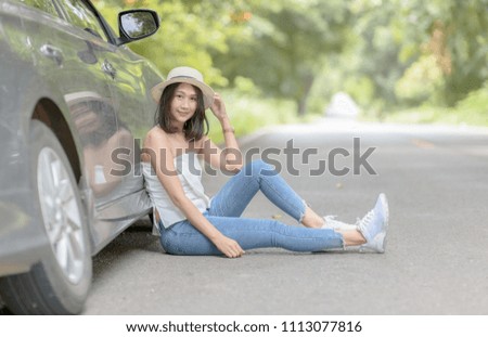 young traveler siting on the road near car, Travel and recreation concept