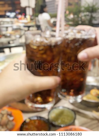 Blurred picture of clinking glasses with non alcohol beverage in the restaurant.