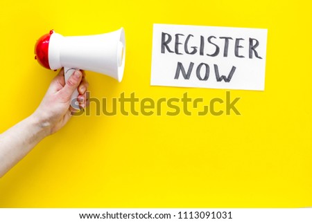 Register now hand lettering icon near megaphone on yellow background top view copy space