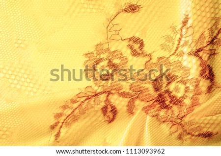 Image texture background, decorative gold lace with pattern. Golden vintage lacy background. Golden lace on white background spandex, macro. Lace decorative floral pattern.