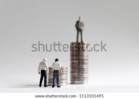 The concept of social issues in economic difficulties due to rapid retirement in an aging society. The stack of coins with miniature people. Royalty-Free Stock Photo #1113101495