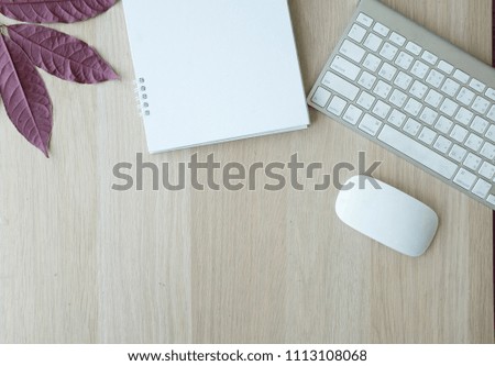 notebook ,tablet  on flatlay and top view with leaves on wooden table background