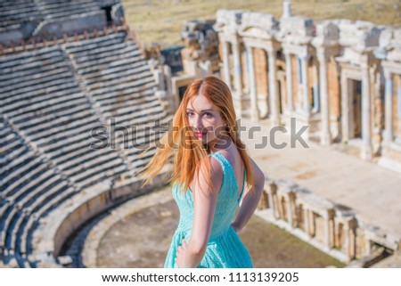 Girl tourist taking picture of Hierapolis in Turkey, Pamukkale, beautiful landscape with ruin, trees and mountain, woman in lace summer dress 