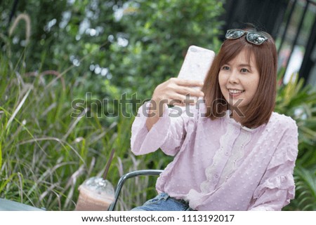 Portrait Asian woman taking selfie in coffee shop