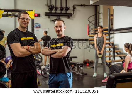 Two successful male personal trainers and gym owners in their gym. Happy because their business is growing Royalty-Free Stock Photo #1113230051