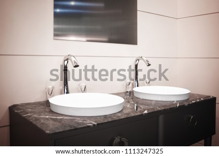 Bathroom  interior in warm beige tones with two sink and faucet