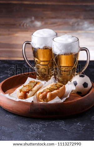 Image of two glasses of beer, hot dogs, soccer ball
