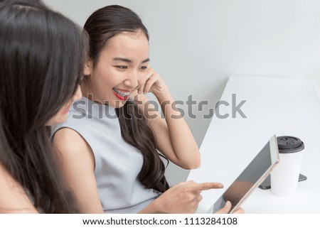 A picture of a smiling young girl paying with a tablet in online shopping. asian women.