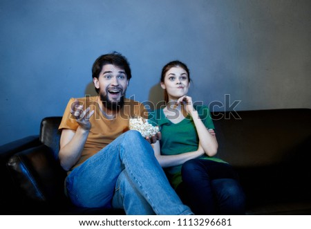 happy man watching television and woman on dark sofa                         