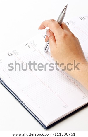 Picture of women hand whit pen and daily planner