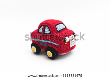small knitted red baby machine on white background