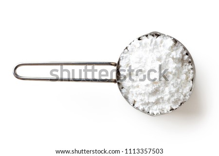 Measuring scoop with powder sugar isolated on white background, top view