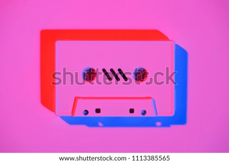 toned pink picture of retro audio cassette on pink surface