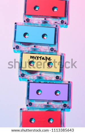 top view of arranged colorful audio cassettes with mixtape lettering on purple background