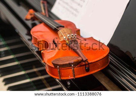 Violin and fiddle stick on the piano