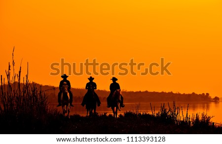 Wild West sunset ; Cowboy Men horse riding at sunset Vintage west.