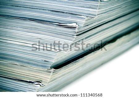closeup of a pile of different magazines on a white background