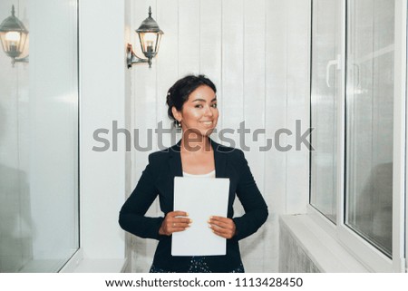 girl in a business suit Asian appearance on a white background in the office working with documents