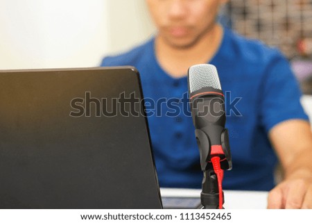 A man using a microphone with a computer notebook. Concept audio and studio recording.