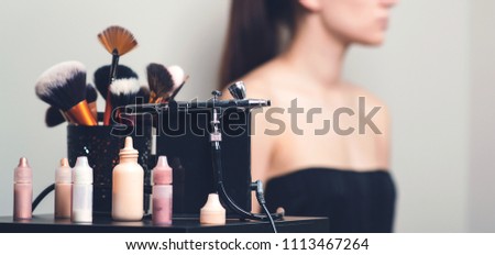 Makeup airbrush and the bottles with paint for body art. Royalty-Free Stock Photo #1113467264