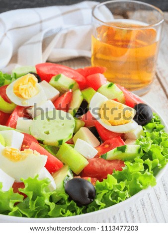 Fresh greek salad with tomatos, cucumber, feta cheese and apple juice or white wine. On white wooden background. Healthy food for diet