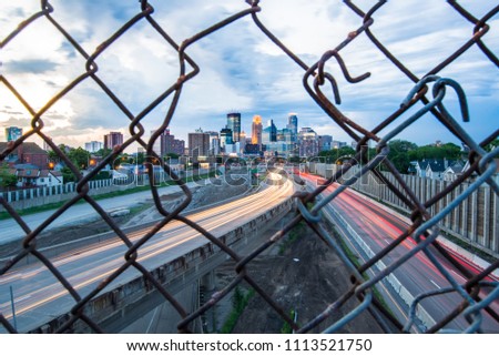 Long exposure shot of 24th Street pedestrian bridge, through the fencing over 35W highway. Car headlight trails  Minneapolis Minnesota USA