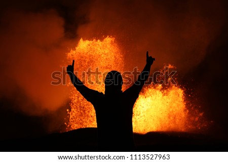 Victory pose in front of a lava fountain of the volcanic eruption of Kilauea in Hawaii