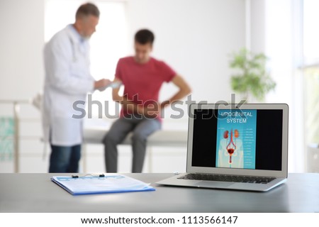 Laptop with picture of urogenital system and blurred people on background