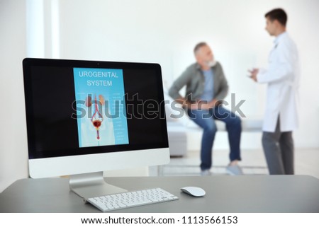Computer monitor with picture of urogenital system and blurred people on background
