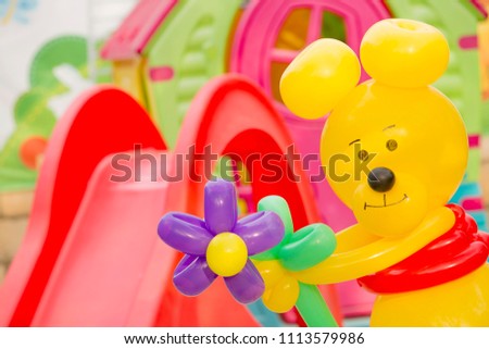 Yellow bear with flowers from balloons congratulates with a holi