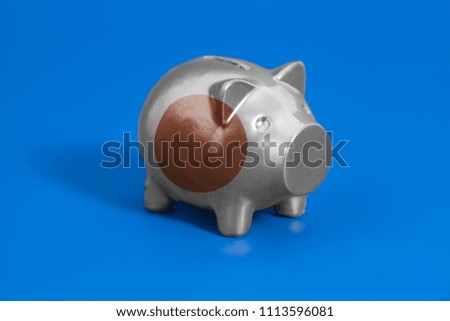 Piggy bank with Japan flag on blue background