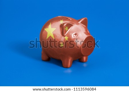 Piggy bank with China flag on blue background