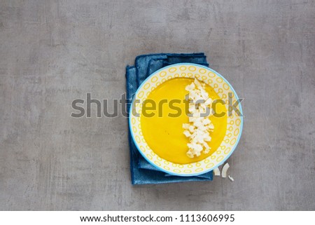 Yellow colorful mango smoothie bowl with coconut chips flat lay. Superfood and detox concept. Top view. Organic food on light copy space background