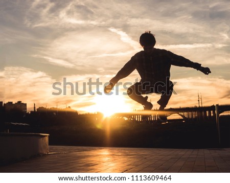 young teenage boy flying in the city against the sky sunset