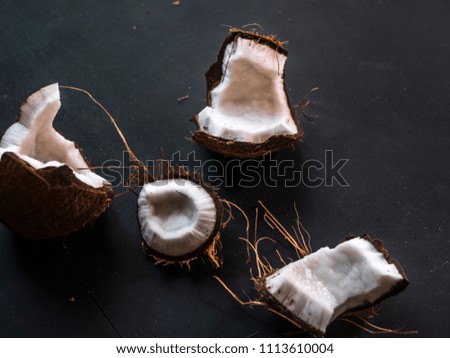 close up raw fresh broken coconut on dark table