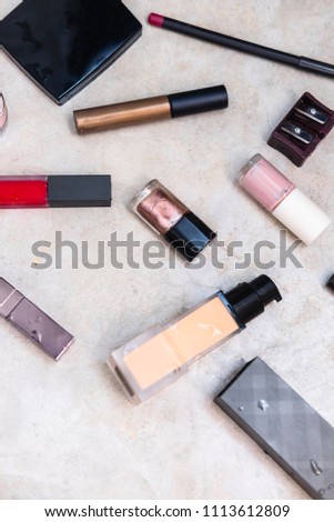Woman's glamour high-end beauty products from above on grey concrete background. MInimalist fashion blogging concept.