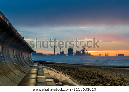Redcar beach at sunset. North east coast of England. Industrial background. Old abandoned steel works. Royalty-Free Stock Photo #1113631013