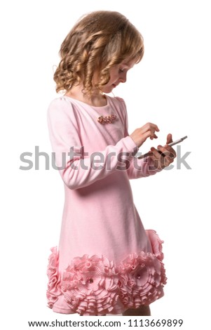 Little girl in pink dress touches the smartphone screen on white background. Isolated.