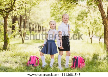 cute blonde girls in school uniform, in white golfs and backpack soutdoors