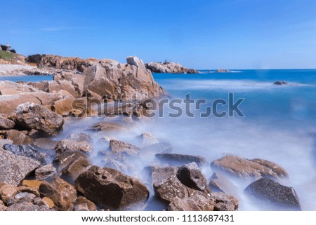 Big waves crashing on beach rocks, long exposure of the feminine pictures