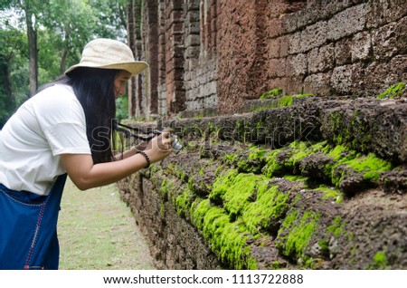 Travelers thai woman walking visit and travel take photo in ancient building and ruins of Kamphaeng Phet Historical Park is an archeological site and Aranyik Area in Kamphaeng Phet, Thailand