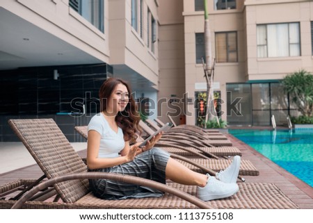 Portrait of pretty cheerful woman resting in vacation on summer season at resort swimming pool