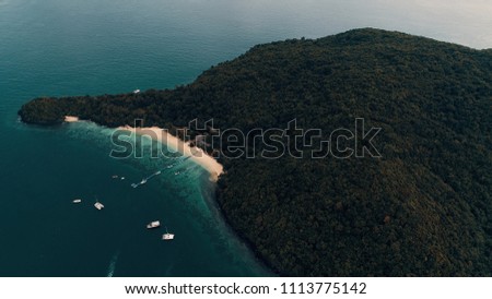 Flight on a dune over the island of KO. Yachts anchored near the island. The beach line, with gentle yellow sand. Bungalows on the beach. The tropical island covers the entire island.