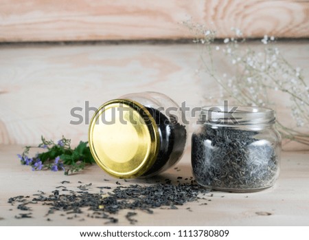 Glass jar with black and herbal tea, still life photo