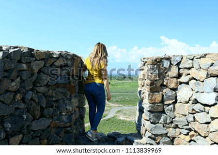 Beautiful girl standing with her back against a beautiful background.